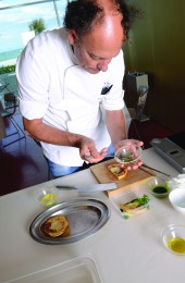 Moreno Cedroni plating the celerianc and lime puree with arugula sauce